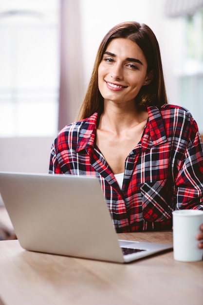 Retrato de mulher jovem sorridente com laptop