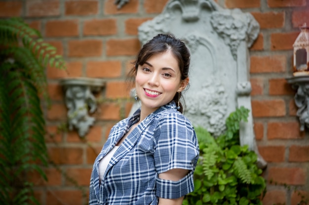 Retrato de mulher jovem sorridente contra jardim