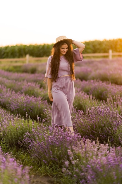 Retrato de mulher linda elegante andando no campo posando olhando o pôr do sol