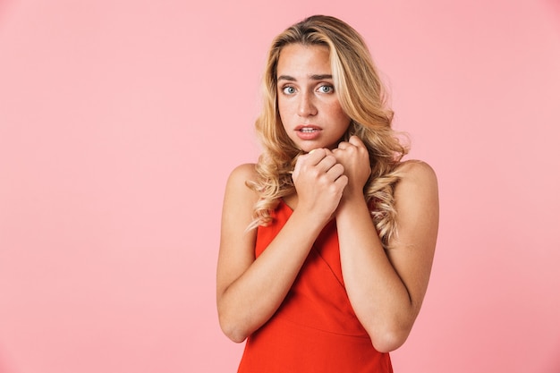 Foto retrato de mulher loira chocada e assustada posando isolada sobre uma parede rosa