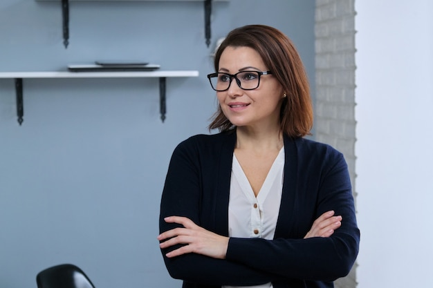 Retrato de mulher madura confiante positiva com os braços cruzados, empresária