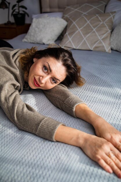 Foto retrato de mulher madura deitada na cama em uma casa aconchegante