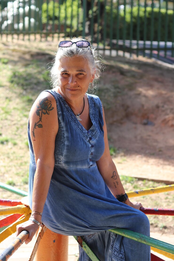 Foto retrato de mulher madura sentada em um corrimão no playground