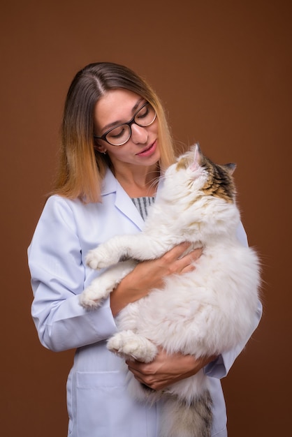 Retrato de mulher médico veterinário segurando gato persa