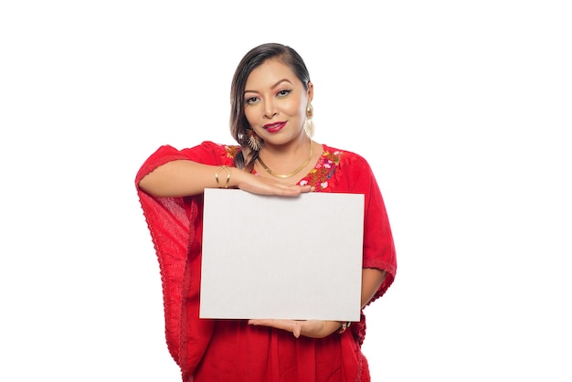 Retrato de mulher mexicana em trajes tradicionais, segurando um cartaz em branco. fundo branco.