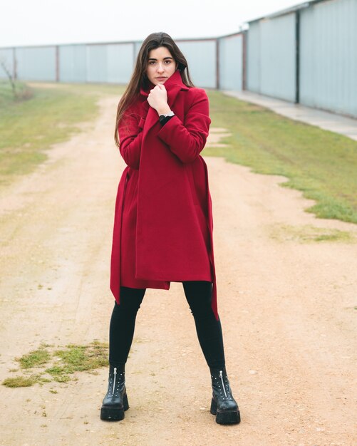 Retrato de mulher moda jovem bonita posando em uma cena rural na europa. moda inverno e primavera, vestindo uma jaqueta vermelha.