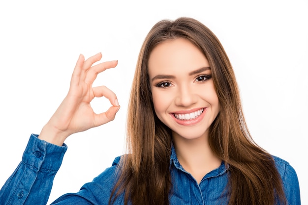 Retrato de mulher morena alegre e alegre mostrando um gesto de ok