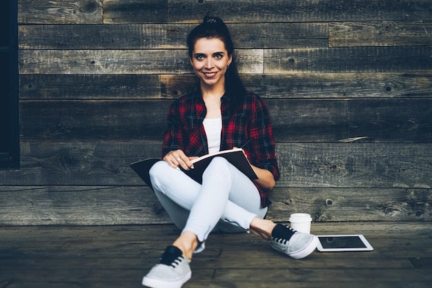 Foto retrato de mulher morena encantadora planejando horário de trabalho gravando informações para notebook