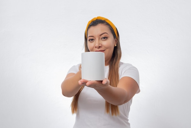 Foto retrato de mulher mostrando uma xícara branca pessoa segurando uma xícara de café fundo branco