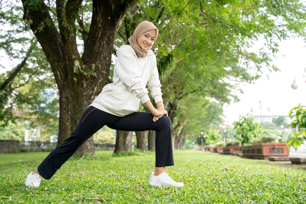 Retrato de mulher muçulmana feliz e divertida fazendo exercícios ao ar livre pela manhã