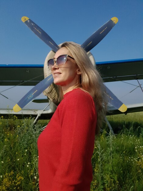 Retrato de mulher na frente de um avião antigo