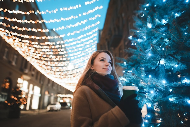 Retrato de mulher na rua com uma xícara de café