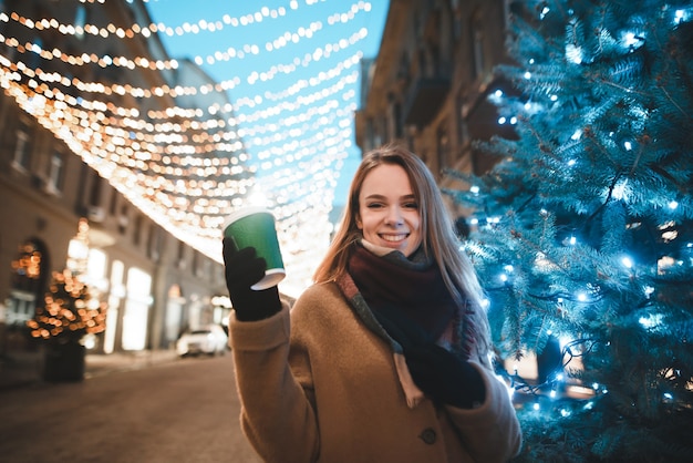 retrato de mulher na rua com uma xícara de café