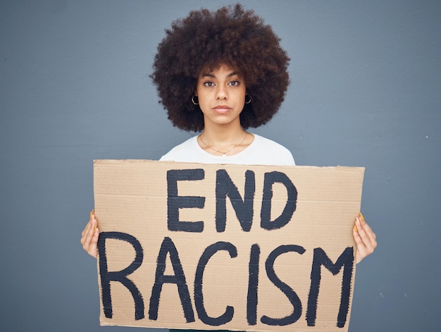 Retrato de mulher negra acaba com racismo e faixa de protesto para apoio à liberdade de ativismo ou independência racial Pessoa afro-americana protestando contra placa e orgulhosa diversidade no estúdio de fundo cinza