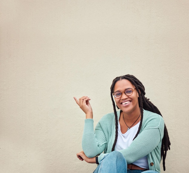 Retrato de mulher negra e mãos apontando para publicidade de maquete ou riso de fundo vazio e rosto de gesto de mão animado e garota relaxam no estúdio enquanto mostram espaço de cópia de parede ou marketing isolado