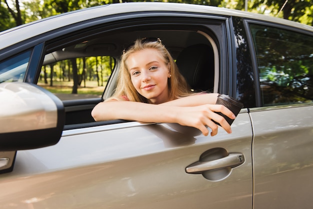 Retrato de mulher no carro com copo de papel