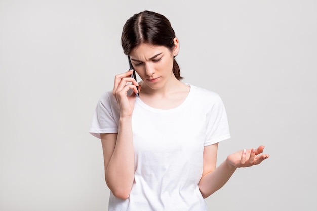 Retrato de mulher perturbada Telefonema Senhora irritada tendo conversa negativa isolada no espaço neutro da cópia Comunicação à distância Tecnologia da informação