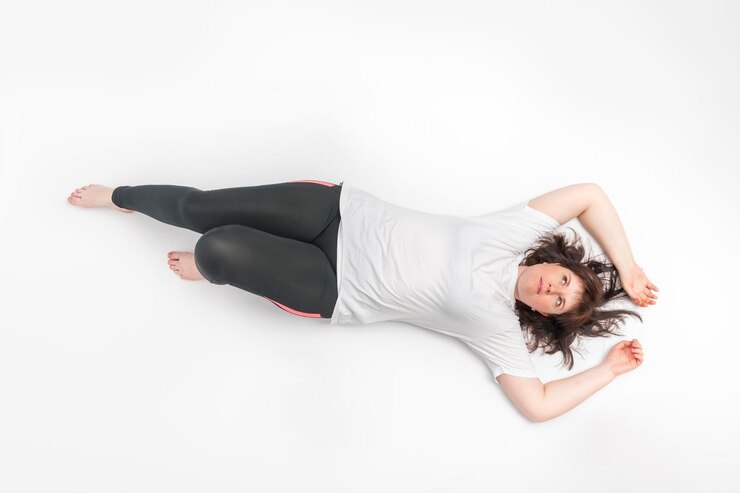 Foto retrato de mulher plus size em roupas esportivas está no fundo branco modelo com figura curvilínea vista superior