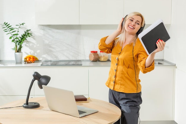 Retrato de mulher que trabalha com o laptop na cozinha brilhante. Coronavírus Covid-19. Distanciamento social