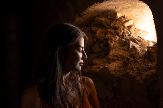 Foto retrato de mulher relaxando recebendo por um buraco na janela em algumas ruínas no méxico