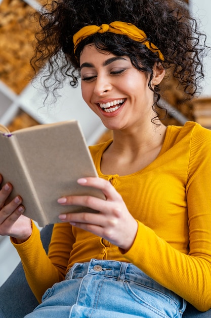 Retrato de mulher rindo enquanto lê um livro