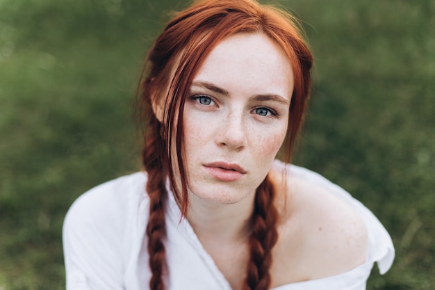 retrato de mulher ruiva ao ar livre com tranças