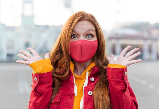 Foto retrato de mulher ruiva com máscara médica