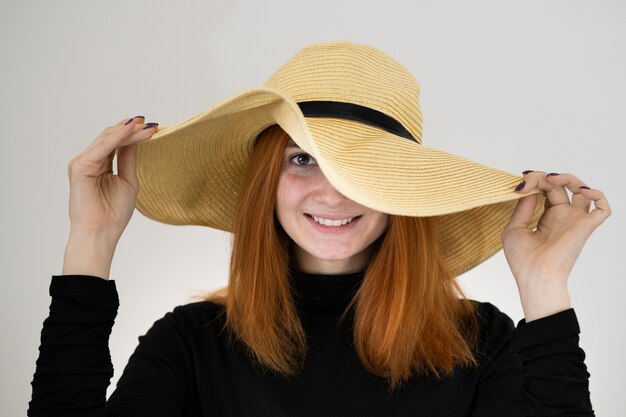 Retrato de mulher ruiva engraçada no chapéu de palha saco amarelo.