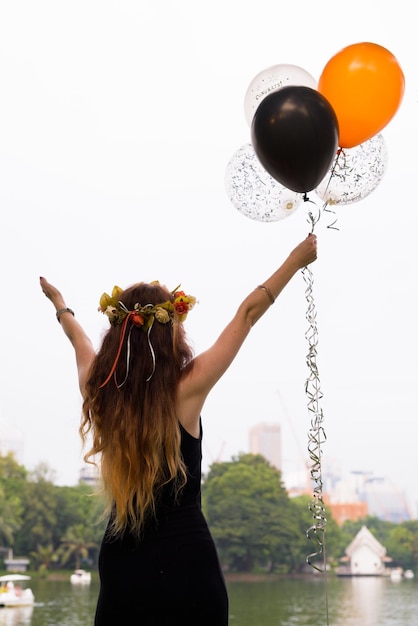 Foto retrato de mulher segurando balões contra o céu