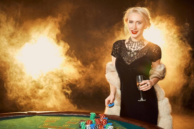 Retrato de mulher segurando fichas de pôquer perto da mesa no cassino