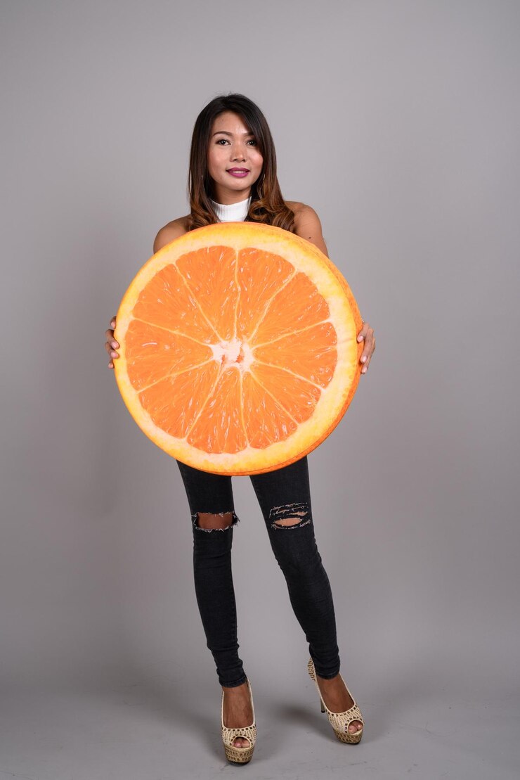 Foto retrato de mulher segurando sorvete de pé contra um fundo laranja