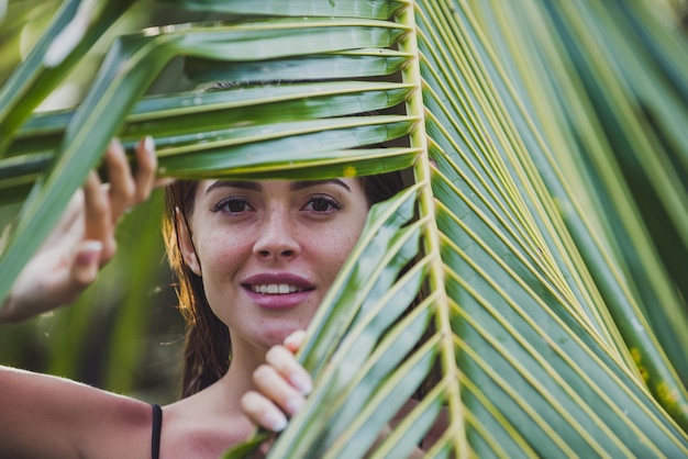 Foto retrato de mulher segurando uma folha de palmeira