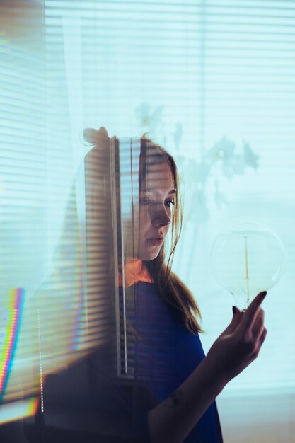 Foto retrato de mulher segurando uma janela de vidro