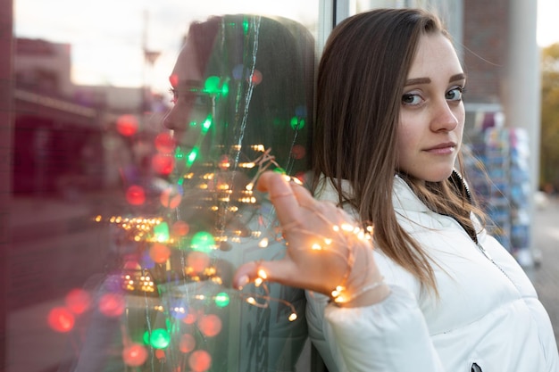 Foto retrato de mulher segurando uma luz de corda iluminada