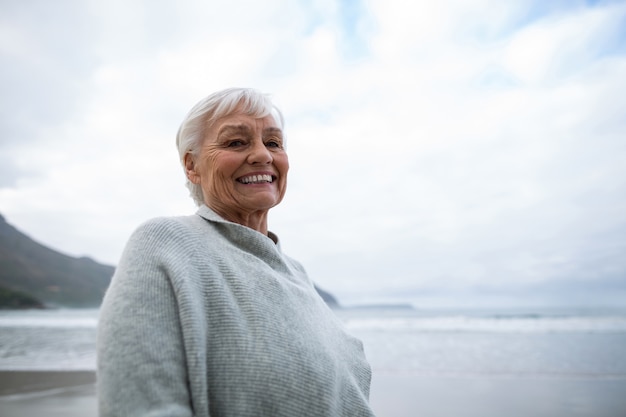 Foto retrato de mulher sênior em pé na praia