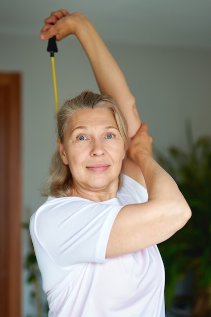 Retrato de mulher sênior exercício para esportes em casa. aptidão doméstica.