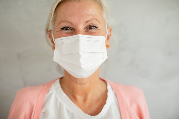 Retrato de mulher sênior usando máscara facial médica protetora para proteção contra vírus