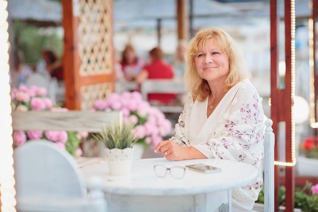 Retrato de mulher sentada no terraço de um café de praia