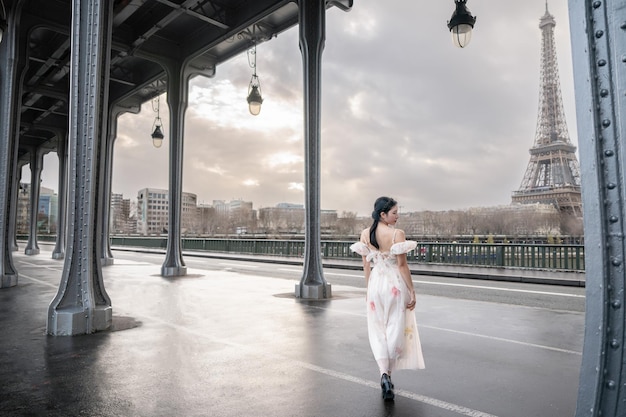 Retrato de mulher sob a ponte bir hakeim com a torre eiffel paris frança