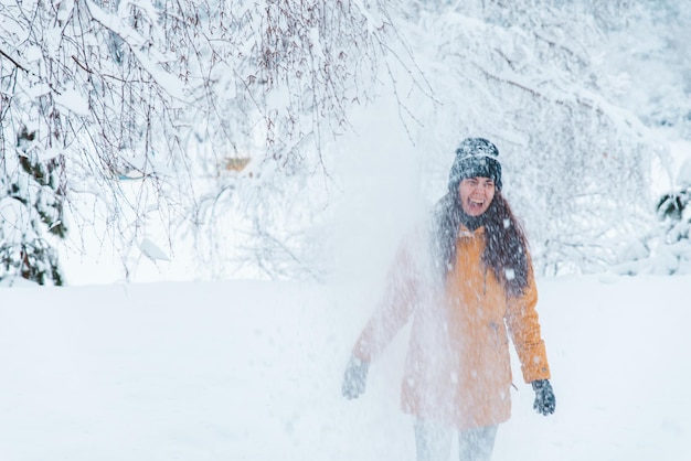 Retrato de mulher sorridente ao ar livre com neve na temporada de inverno do chapéu