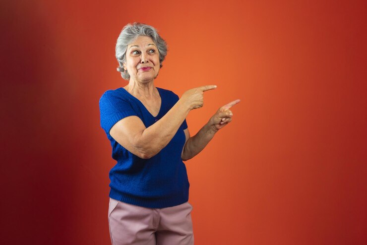 Foto retrato de mulher sorridente com cabelos grisalhos e camiseta azul isolado sobre fundo laranja