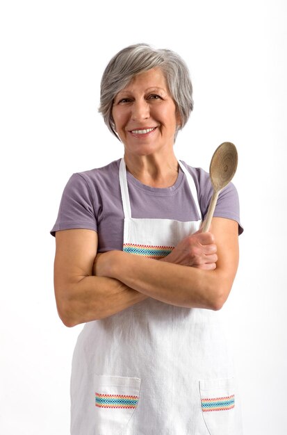 Retrato de mulher sorridente com colher de madeira de pé contra fundo branco