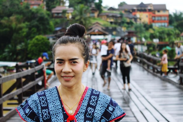 Foto retrato de mulher sorridente em uma ponte pedonal na cidade