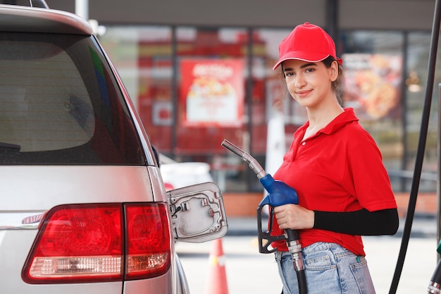 Foto retrato de mulher sorridente trabalhando em um posto de gasolina