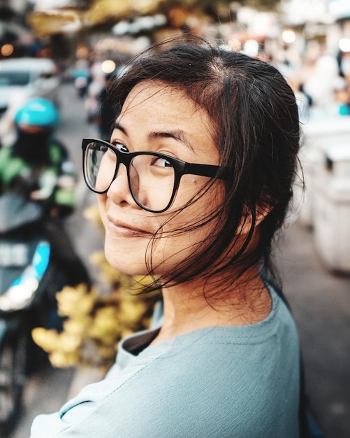 Retrato de mulher sorridente usando óculos na rua