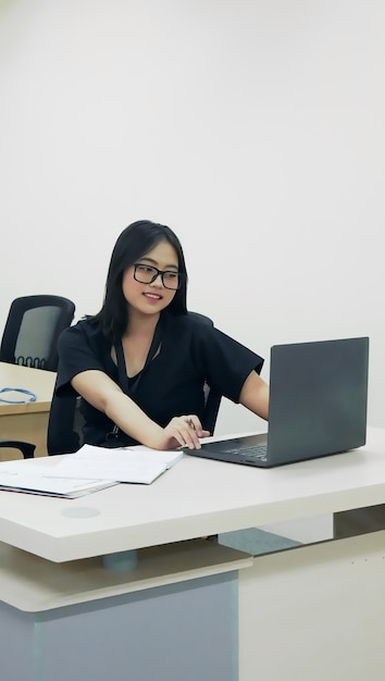 Retrato de mulher trabalhadora de escritório de óculos alegre no trabalho