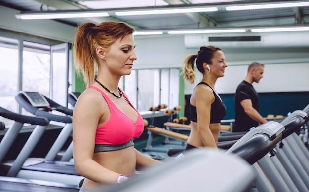 Retrato de mulher treinando em uma esteira na academia