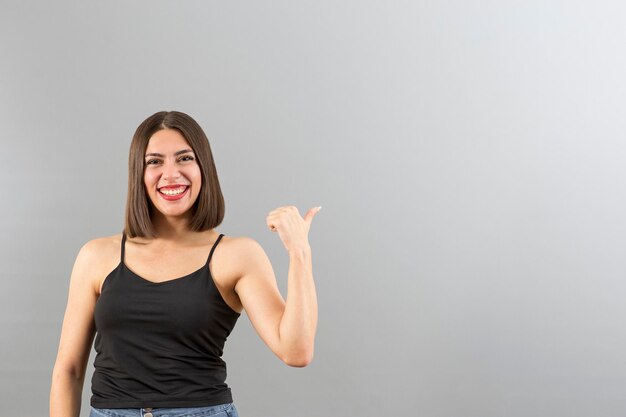 Retrato de mulher turca atraente em humor positivo Ela está gesticulando polegares para cima