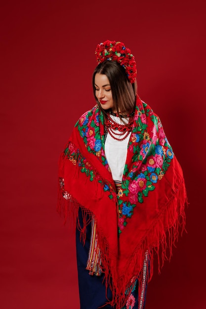 Retrato de mulher ucraniana em roupas étnicas tradicionais e grinalda vermelha floral com lenço no fundo do estúdio magenta viva Chamada de vestido bordado nacional ucraniano vyshyvanka