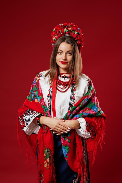 Retrato de mulher ucraniana em roupas étnicas tradicionais e grinalda vermelha floral com lenço no fundo do estúdio magenta viva Chamada de vestido bordado nacional ucraniano vyshyvanka